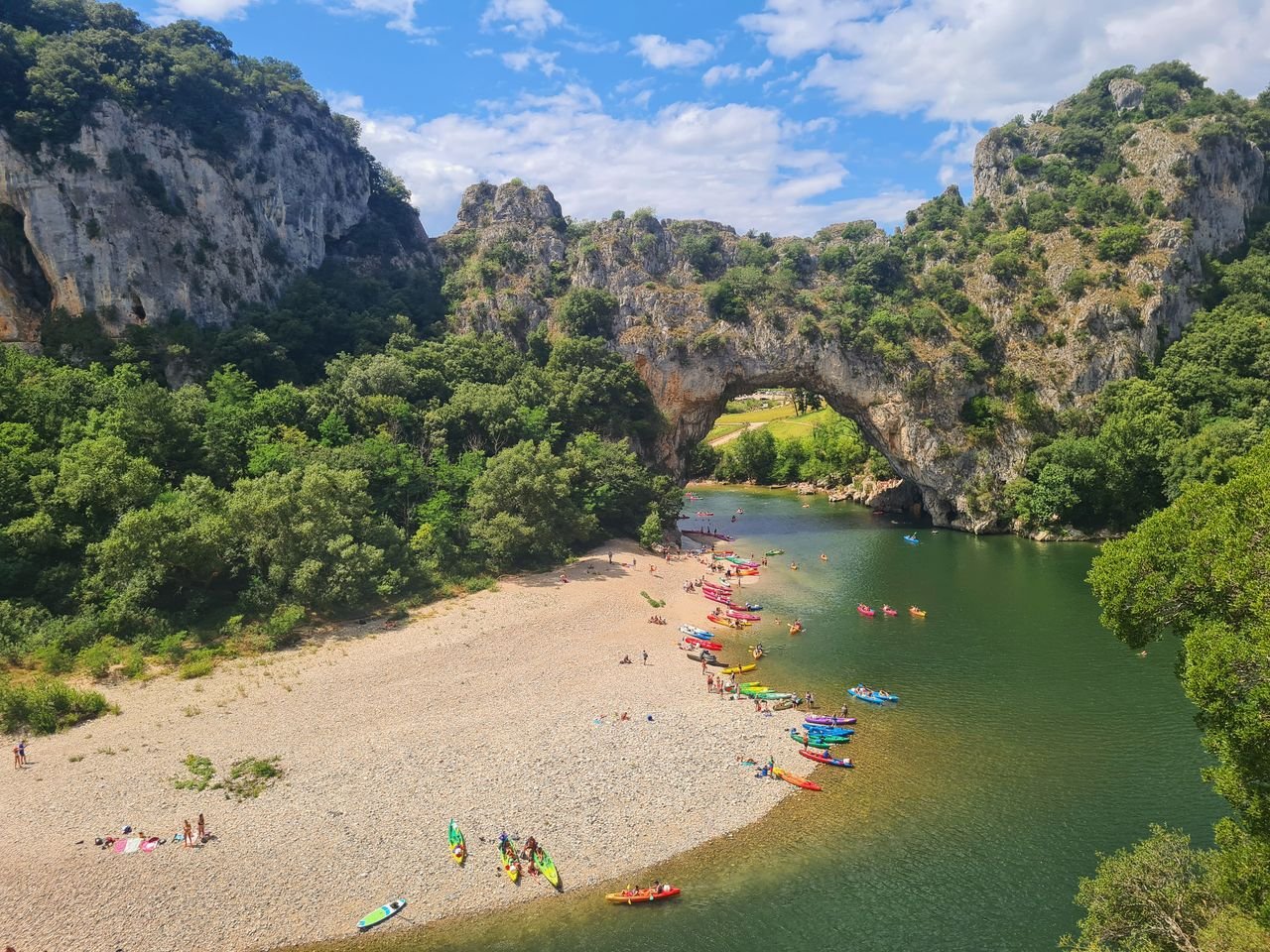 A propos Vibrant scene of kayakers at the iconic Pont dArc in Ardèche Gorge, France.